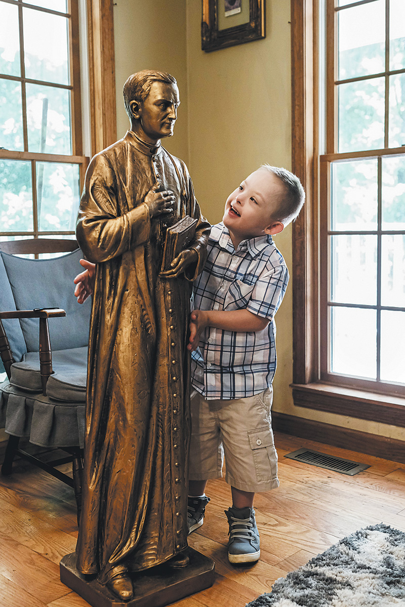 Mikey Schachle med en statue av p. Mikael McGivney i familiens hjem i Dickson i Tennessee